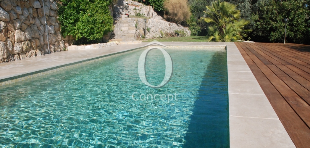 Beige mosaic tiles making a green pool by Ô Concept